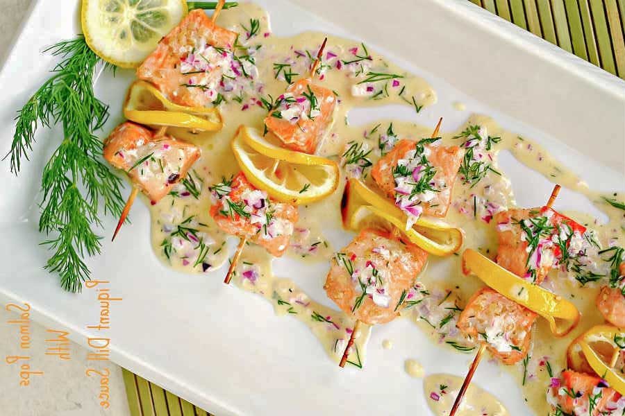 salmon skewers with sauce on a platter