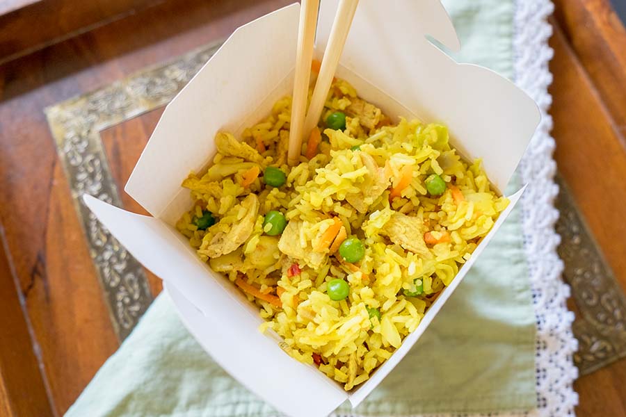 curry pork fried rice in a take out container