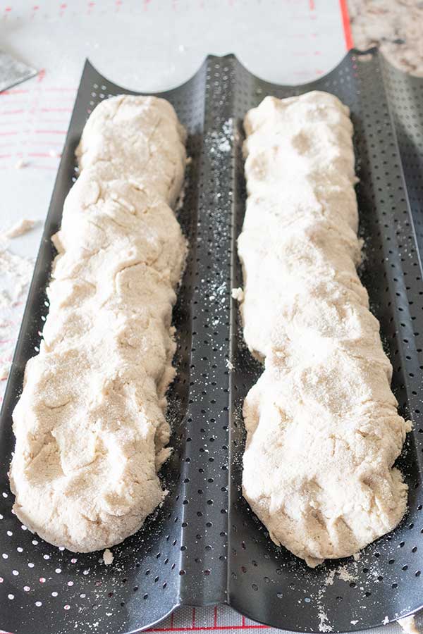 bread dough shaped into loaves in a French baguette pan