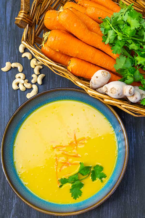 vegan carrot ginger soup with carrots in a basket