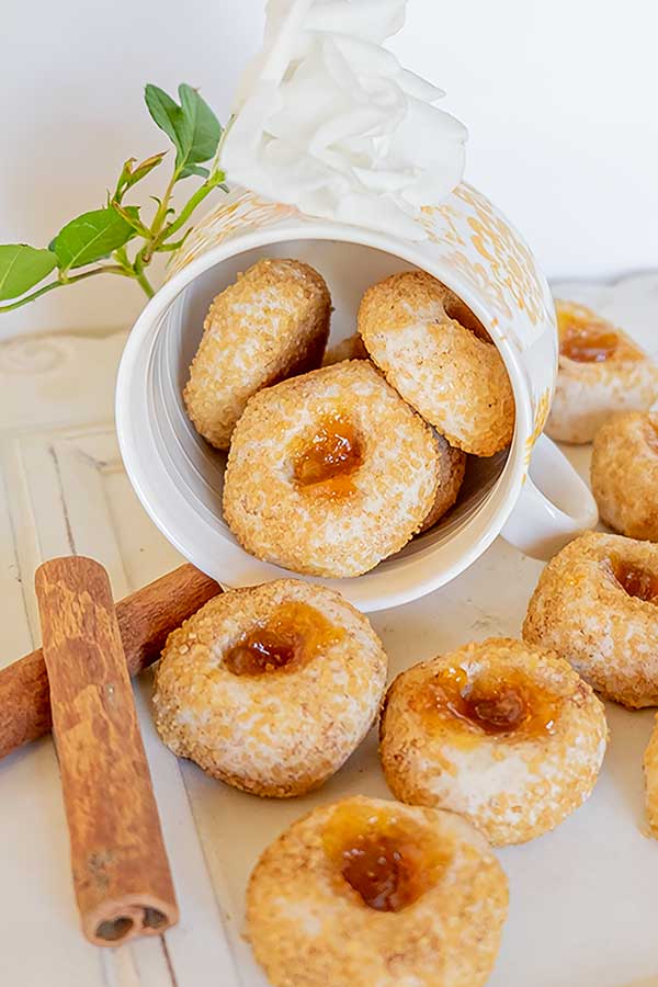 thumbprint cookies, cinnamon stick and a cup