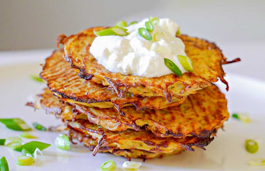 stack of potato pancakes topped with sourcream