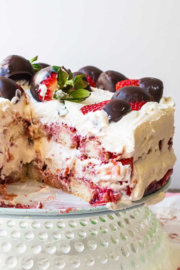 strawberry tiramisu cake on a plate missing a slice