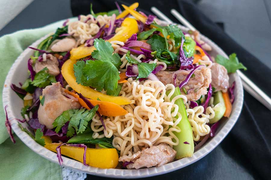 ramen noodle salad in a bowl with chicken and veggies, gluten free