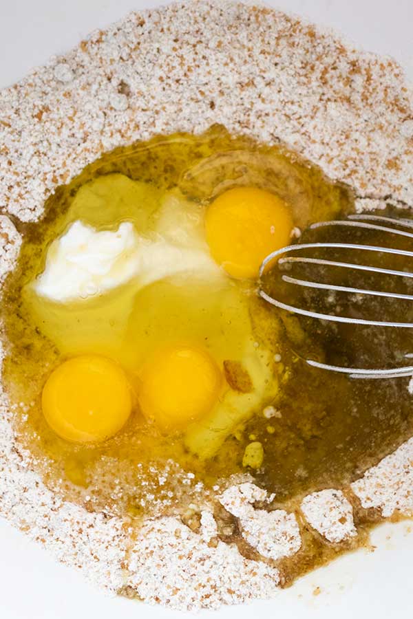 flour eggs olive oil sugar yogurt in a bowl