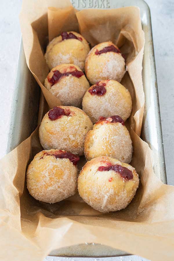 8 baked jelly donuts in a loaf pan lined with paper