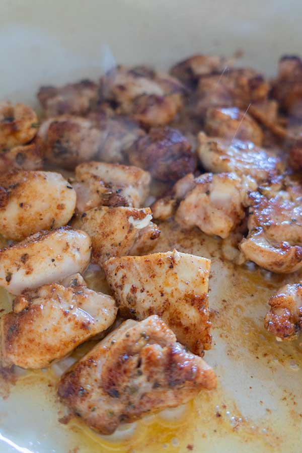 chicken pieces browning in a skillet