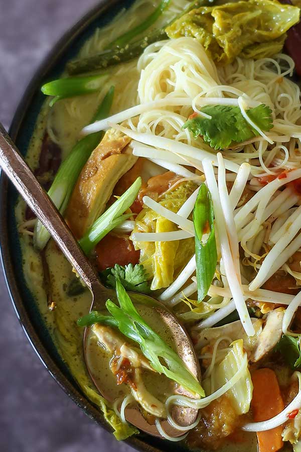 laksa soup with a close up of the coconut broth in a bowl